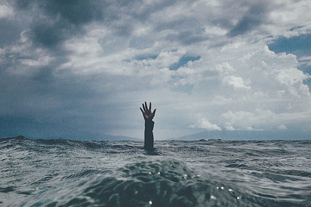 person's hand on body of water thumbnail