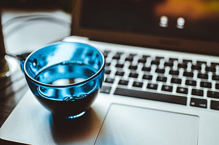 Shallow Focus Photography of Blue Glass Cup on Silver Laptop Computer thumbnail