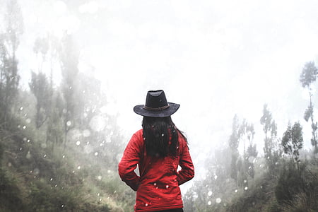 woman in red jacket standing between trees thumbnail