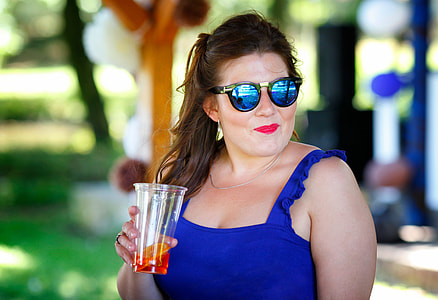 smiling woman wearing sunglasses holding clear plastic disposable cup thumbnail