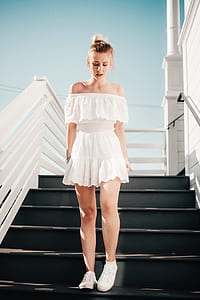 woman wearing white strapless dress standing on stairway during daytime thumbnail