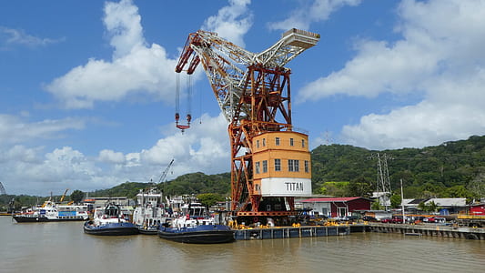 ships docked beside dock crane at daytime thumbnail