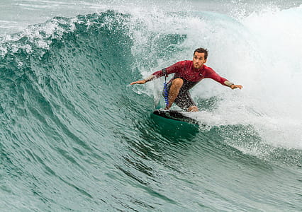 man surfing during daytime thumbnail
