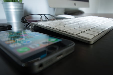 Apple Magic Keyboard beside black iPhone thumbnail
