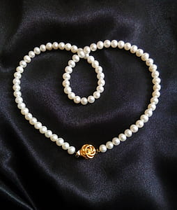 white pearl necklace on black textile thumbnail