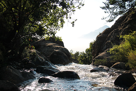brown rocky hills near body of water and green leafed trees during daytime thumbnail