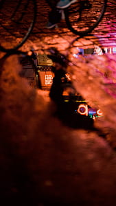 selective focus photography of reflection of neon lights on puddle of water on road thumbnail