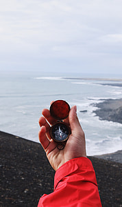person holding compass pointing at north thumbnail