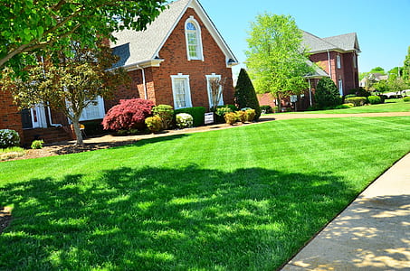 brown brick house near green grass field thumbnail