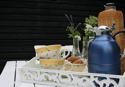 teapot, teacups, bottle and bread on white tray thumbnail