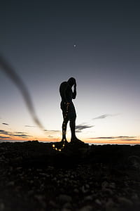 silhouette of man holding string lights during golden hour thumbnail