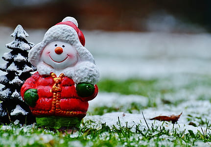 tilt shift focus photography of snowman stand on snow field thumbnail