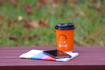 red Mc Cafe cup beside black Android smartphone thumbnail