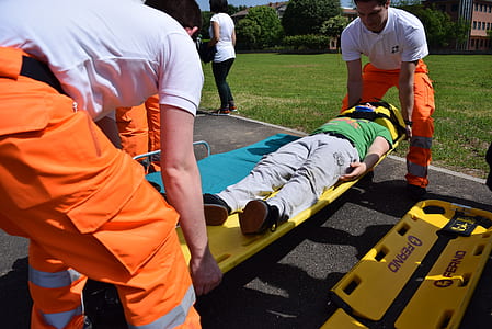 two men carrying person lying on stretcher thumbnail