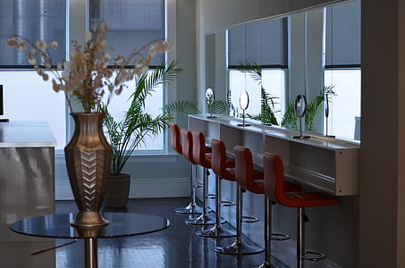 bronze-colored vase on top of round glass-top table thumbnail