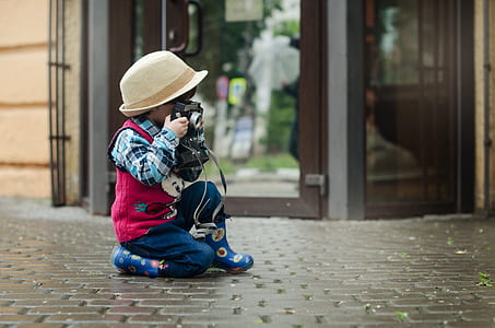 boy in blue dress shirt and dress vest holding camera thumbnail