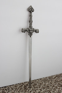 grey stainless steel sword near white concrete wall thumbnail