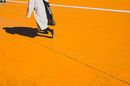 person in white robe walking on orange top road thumbnail
