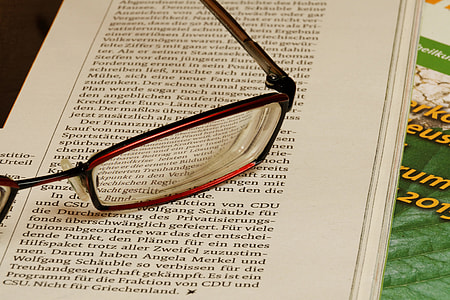 close-up photography of red eyeglasses on white printer paper thumbnail