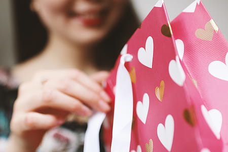 Young girl unpacking a gift. Valentine’s Day. thumbnail