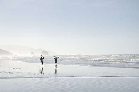 silhouette of two person walking on beach shore during day thumbnail