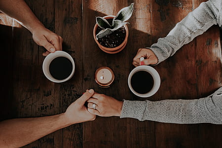 flat lay photography of couple holding hands white drinking coffee thumbnail