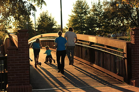 group of people on brown wooden bridge during sunset thumbnail