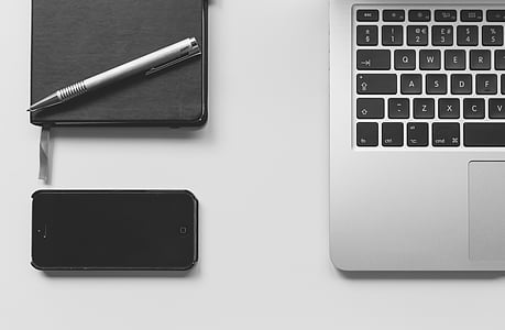 black iPhone 5 beside MacBook thumbnail