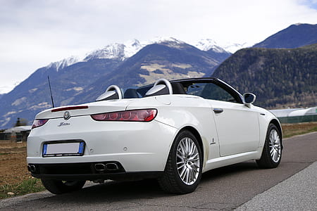 white Alfa Romeo convertible car on roadside thumbnail
