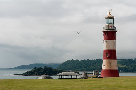 red and white lighthouse near body of water thumbnail