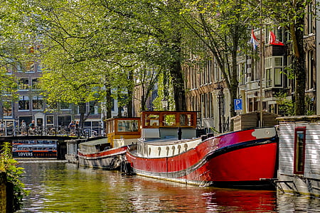 red wooden boat on body of water thumbnail