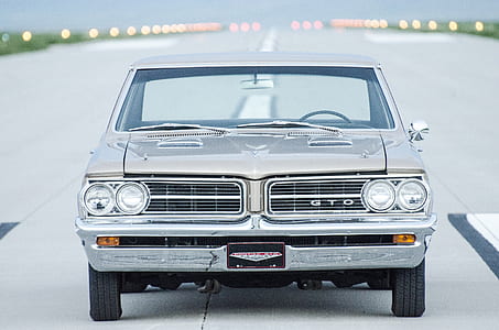 silver Pontiac GTO coupe on grey pavement thumbnail