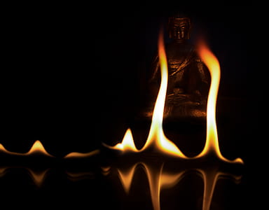 yellow flames in front of Buddha statue thumbnail