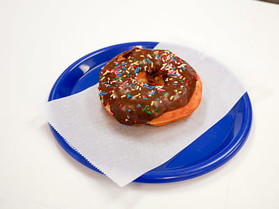 Chocolate donut on a blue plate with a white background thumbnail