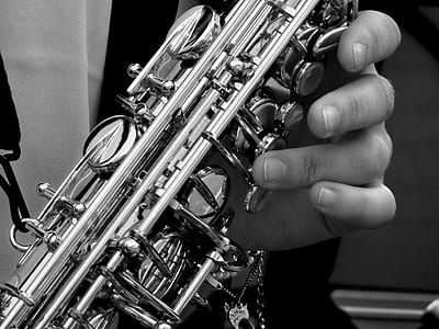grayscale photography of person playing saxophone thumbnail