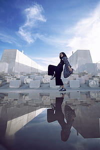 woman walking beside concrete blocks thumbnail