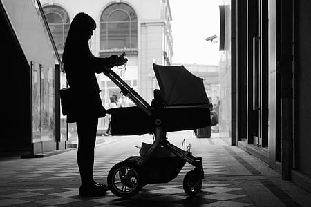 silhouette of woman beside bassinet stroller thumbnail