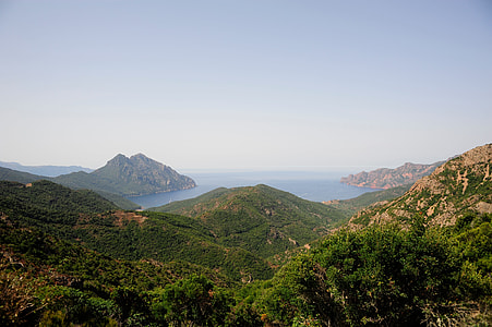 aerial photography of green mountain on body of water thumbnail