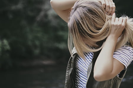 woman in grey vest fixing her hair thumbnail