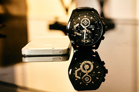 Black Chronograph Watch Besides Iphone on Table thumbnail