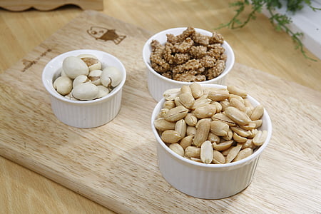 brown nuts and white eggs on white ceramic bowls thumbnail