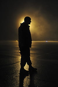 silhoutte of man standing on black concrete pavement thumbnail