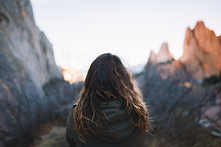 selective focus photography of woman wearing black leather top overlooking mountain thumbnail