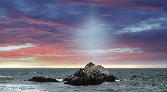grey stones on sea under blue and red sky thumbnail