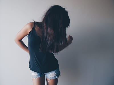 woman standing beside white wall thumbnail