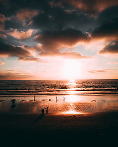 group of people on seashore during golden hour thumbnail