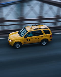 tanning photography of taxi moving forward on truss bridge thumbnail