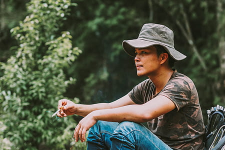 person smoking cigarette wearing bucket hat thumbnail