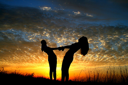 silhouette photography of woman standing on grass thumbnail