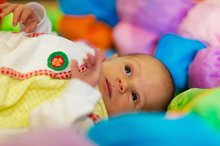 baby lying on multicolored pad thumbnail